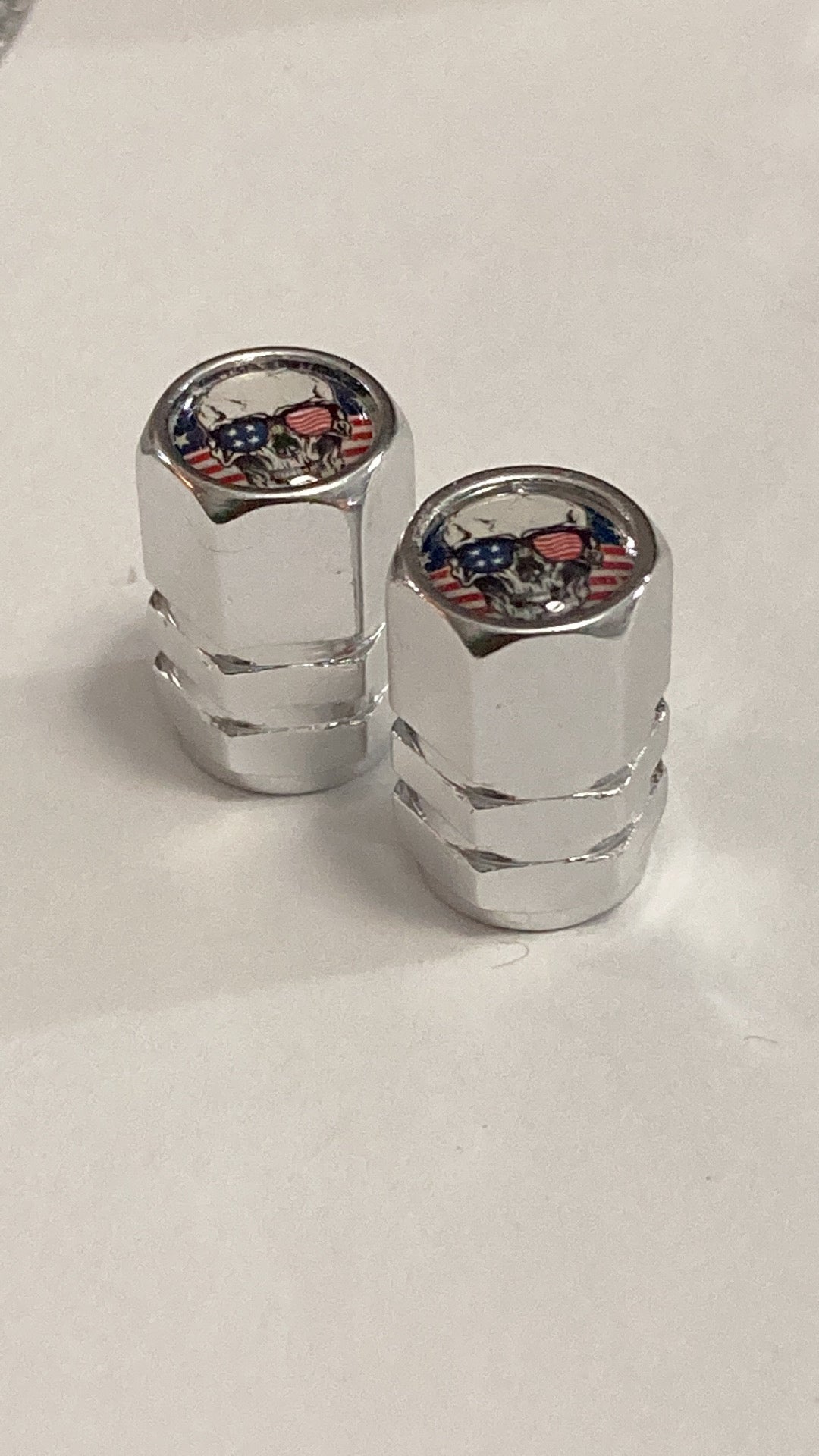Chrome hex-style valve stem caps with a Patriotic Skull logo - 4pcs