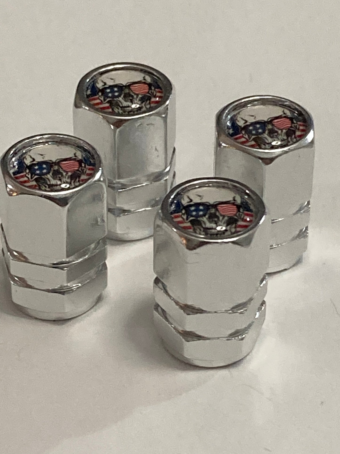 Chrome hex-style valve stem caps with a Patriotic Skull logo - 4pcs