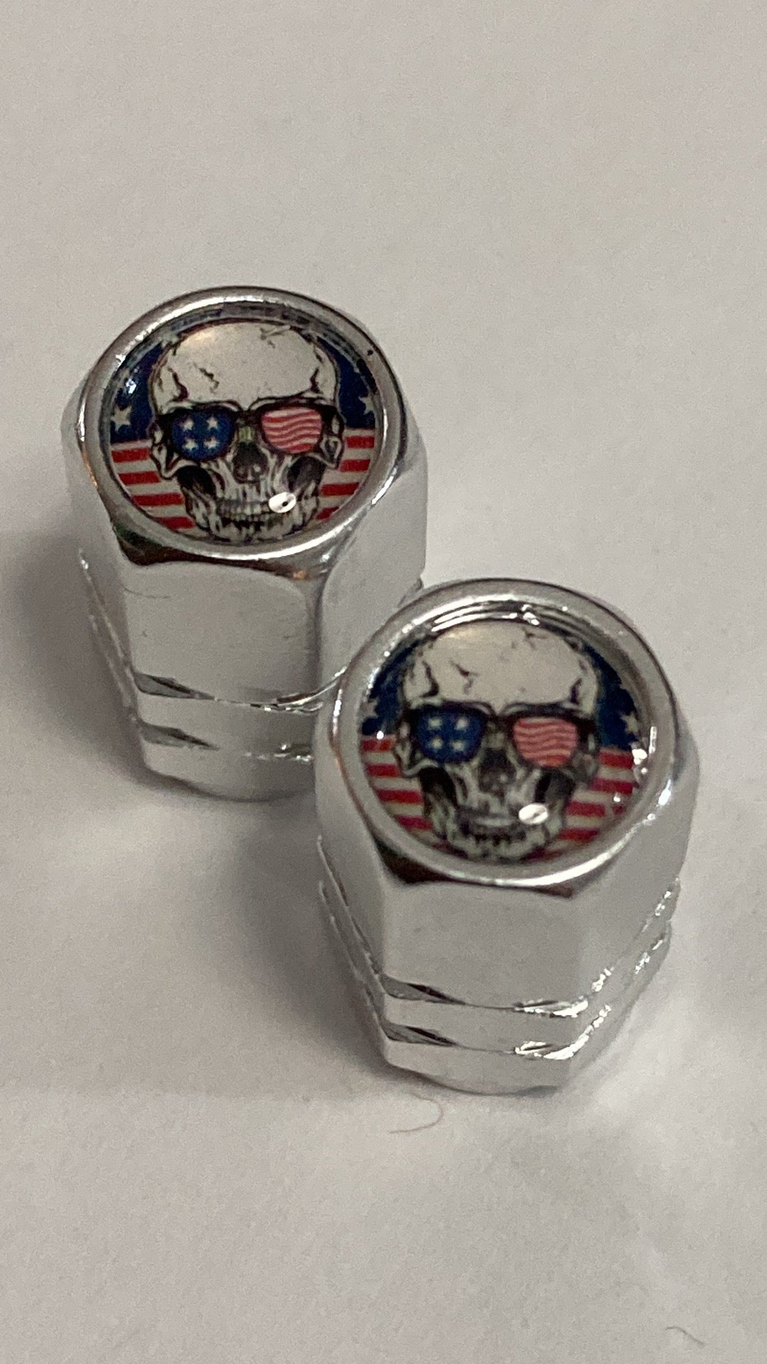 Chrome hex-style valve stem caps with a Patriotic Skull logo - 4pcs